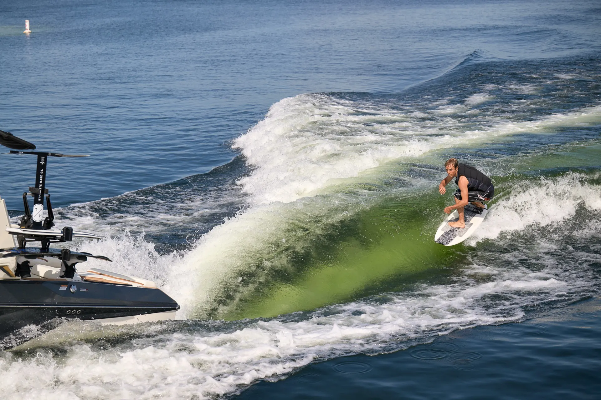 A surfer riding the wave behind a Super Air Nautique G23
